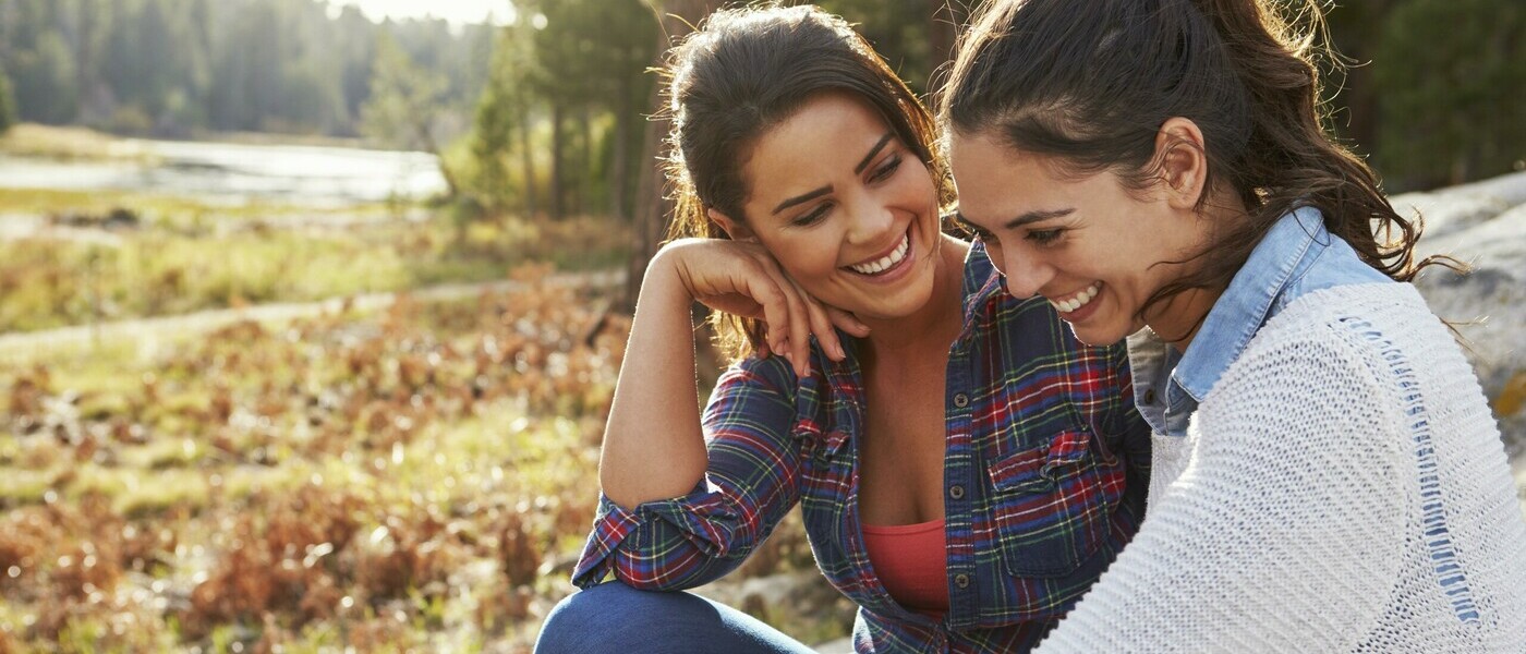 LGBTQ couple smiling together, location: outdoors fall